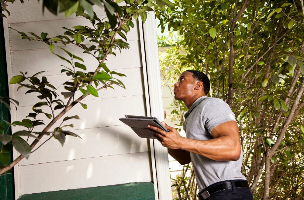 man with clipboard inspecting a home